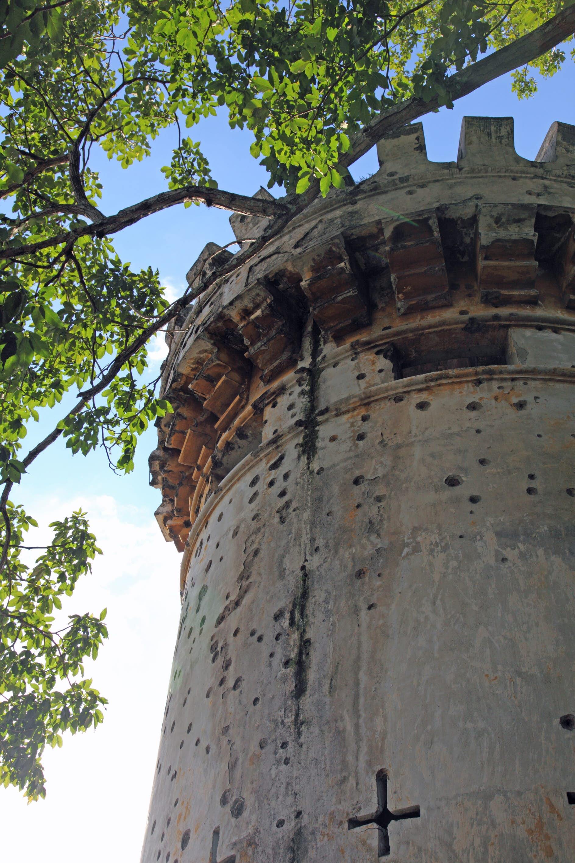 Spanish colonial era tower with battlements and multiple bullet holes, National Museum of Costa Rica.