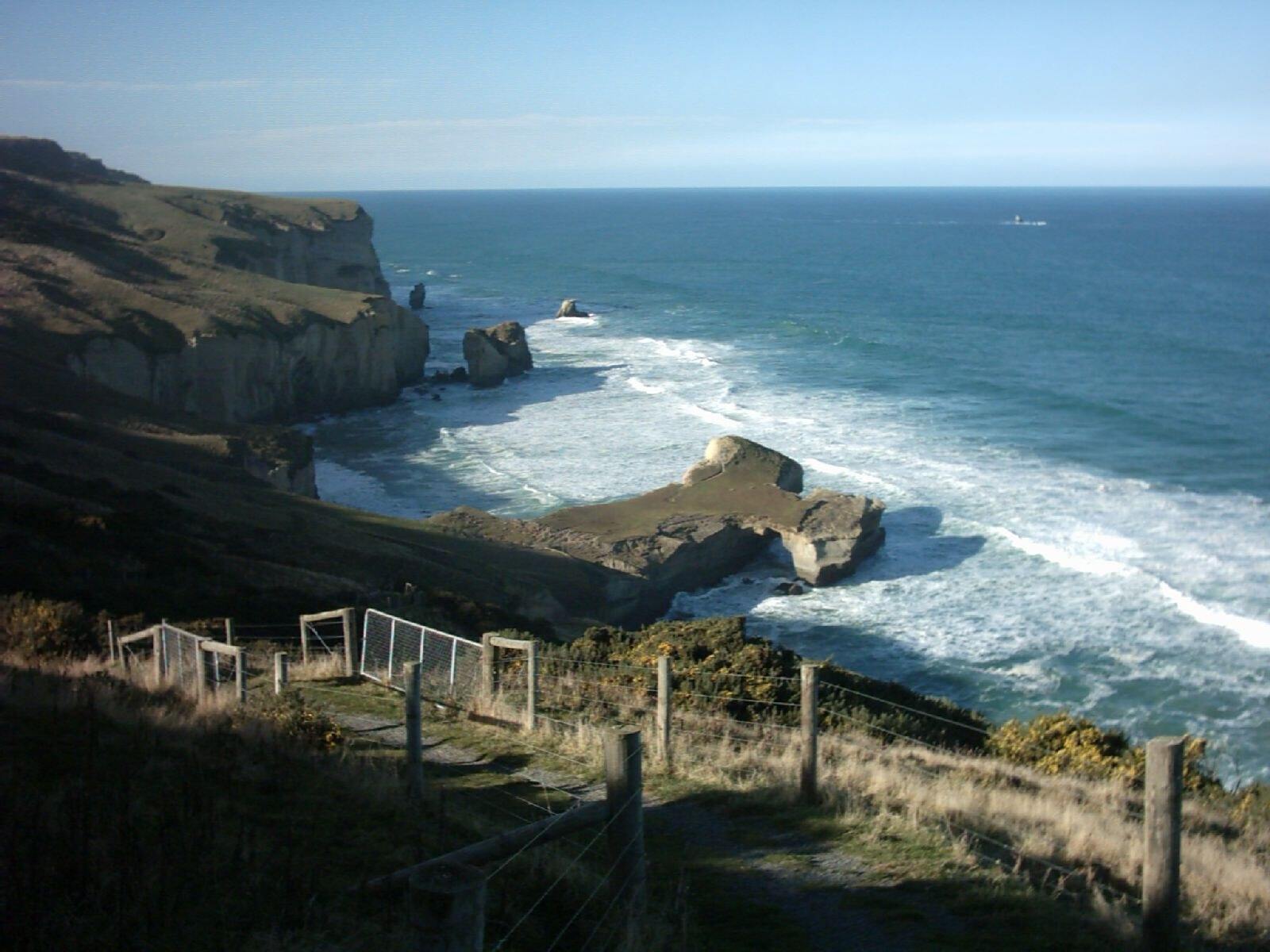 Tunnel Beach, close to Dunedin, New Zealand. The tunnel down to the beach is approximately at the base of the 'T' of the cliff peninsula, and goes…