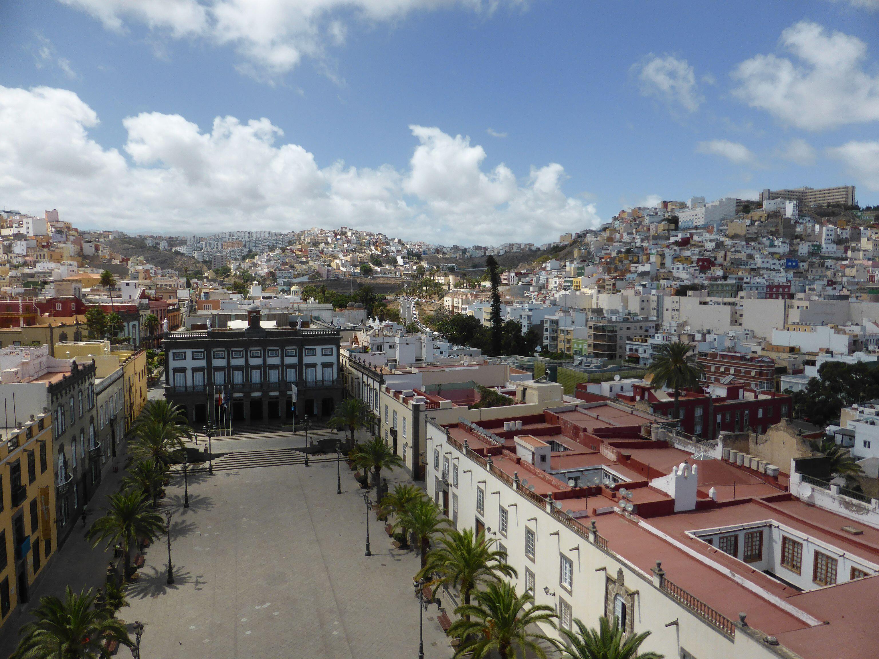 Vista tomada desde lo alto de la fachada principal de la Catedral de Santa Ana, en la ciudad de Las Palmas de Gran Canaria. Se ve la plaza de Santa Ana, donde se encuentra el Ayuntamiento (Casas Consistoriales ), en el barrio de Vegueta. A lo lejos, se levantan los riscos de San Roque y San Nicolás, suburbios históricos de la ciudad.