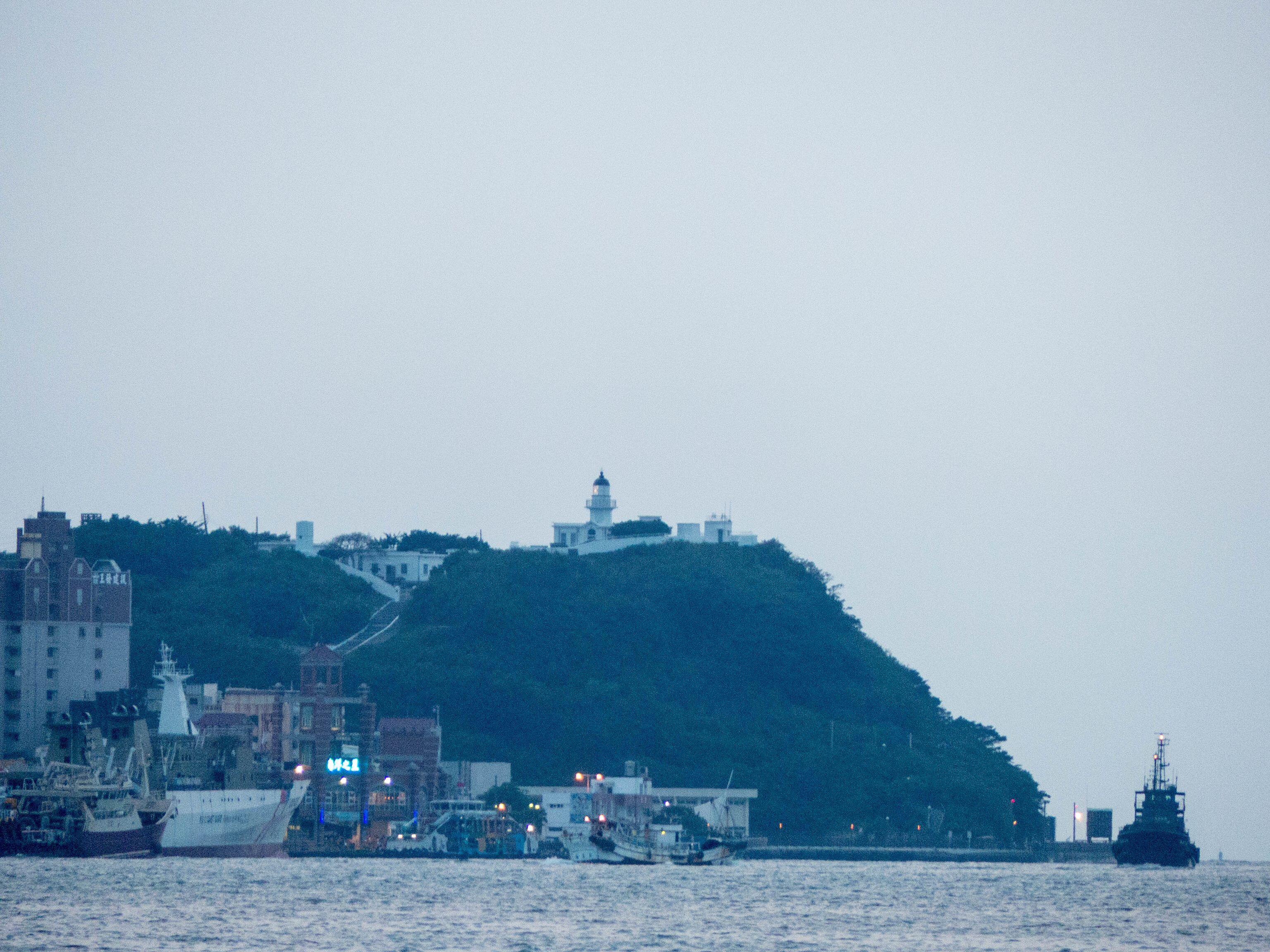 黃昏時由高雄市前鎮區星光水岸公園西北遠眺旗后山旗後燈塔。