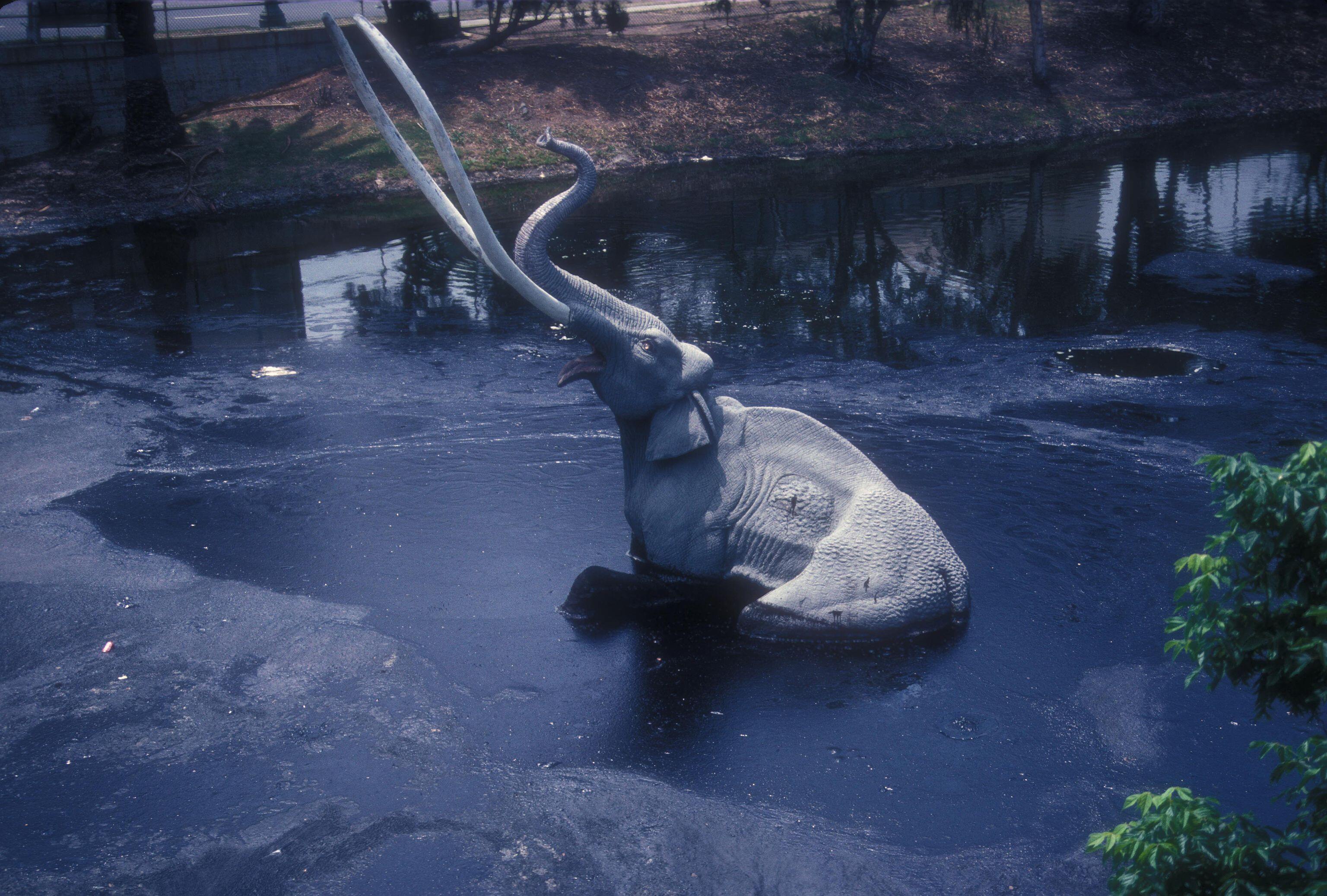 LAKE PIT WITH LIFE-SIZE MODELS OF MAMMOTHS WITH ONE ENTRAPPED IN THE TAR