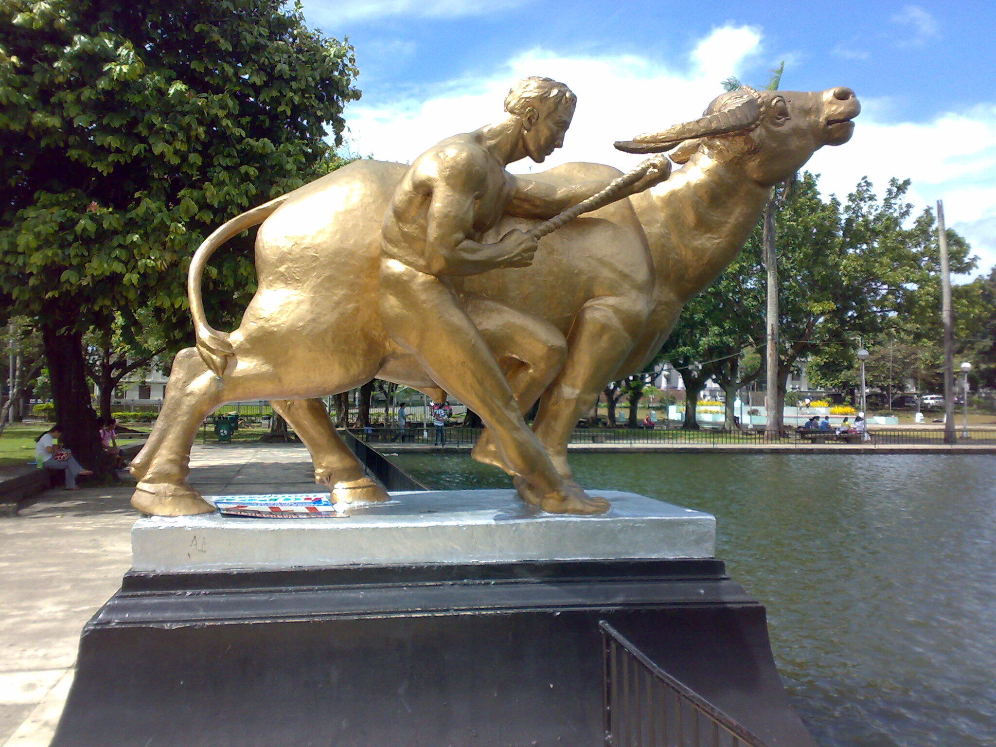 Sculpture on the northern end of the Capitol Lagoon, Bacolod City, Philippines. It depicts a man alongside a water buffalo.