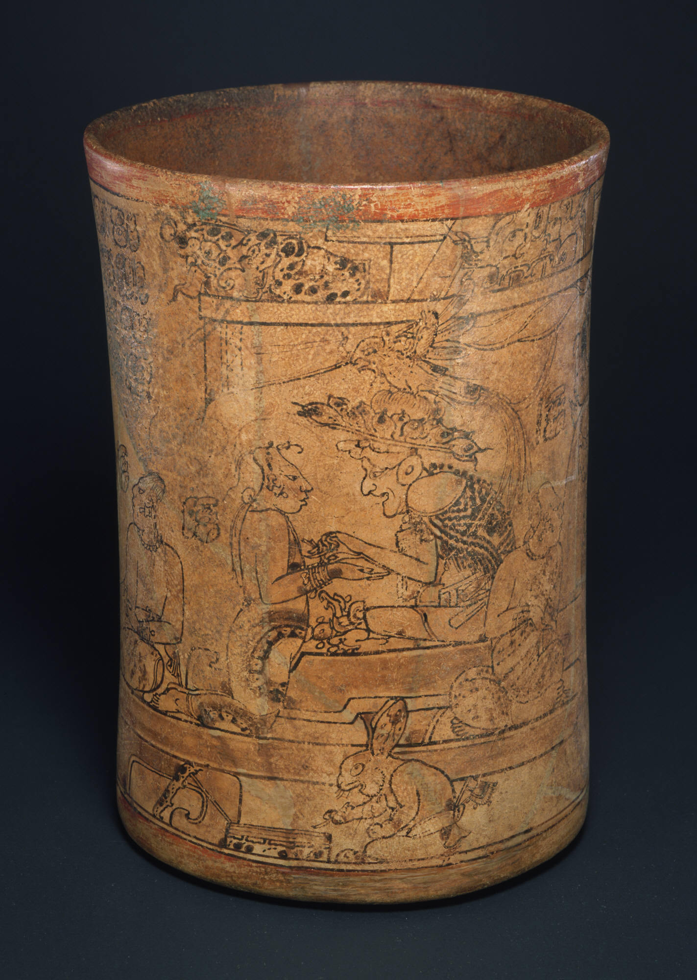 Catalogue Entry:The masterful calligraphic painting on the Princeton Vase is the finest known example of Maya "codex style" ceramic art. Graceful, sure lines painted on a cream slip present a theatrically composed mythological scene, while subtle visual devices encourage the viewer to turn the drinking vessel, adding a temporal unfolding to the visual experience. On one side (seen here), an old, toothless underworld god sits on a throne that is placed within a conventionalized depiction of a palace…